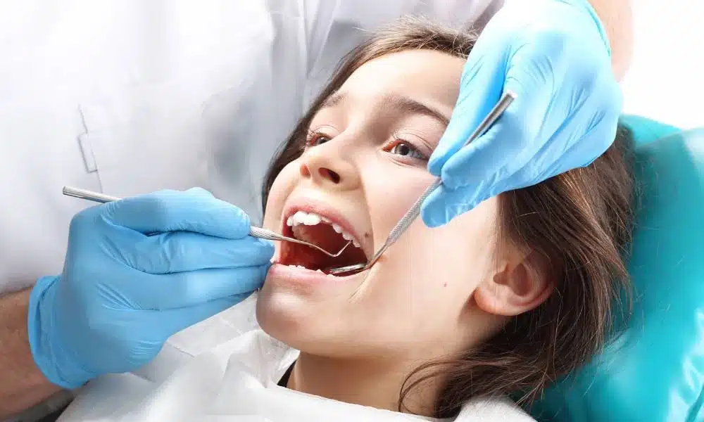 Copil în timpul unei evaluări stomatologice pentru sigilări dentare